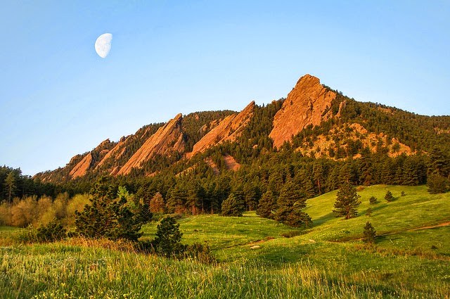Flatirons in Boulder, Colorado. Tall Evergreens are growing at the base of the flatirons.