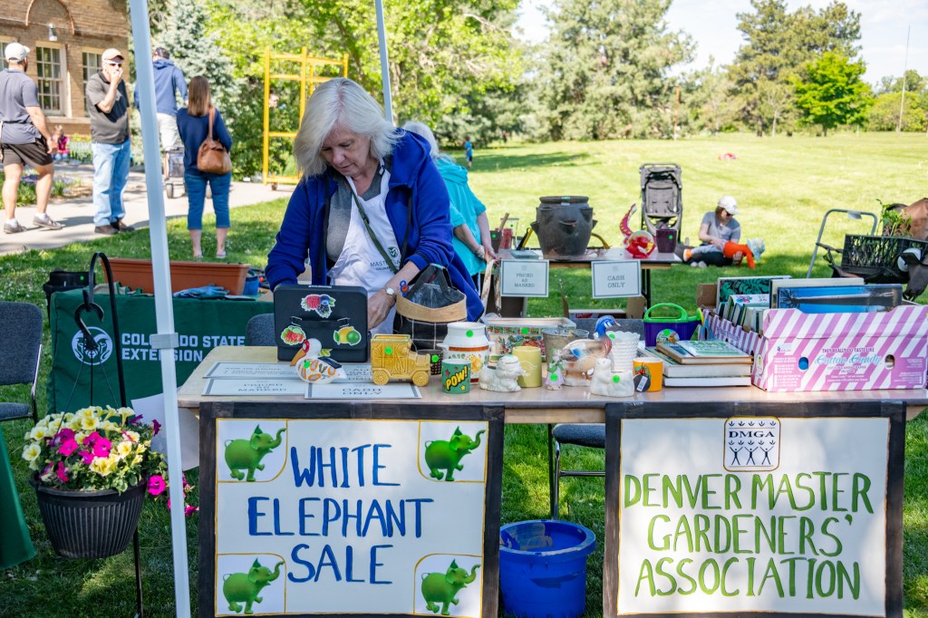 A woman tends to a booth at a public market
