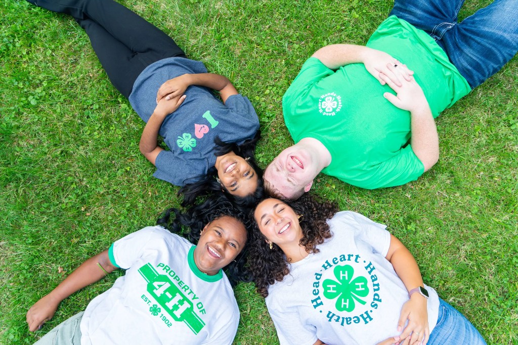 A group of 4-H youth relax together on the grass