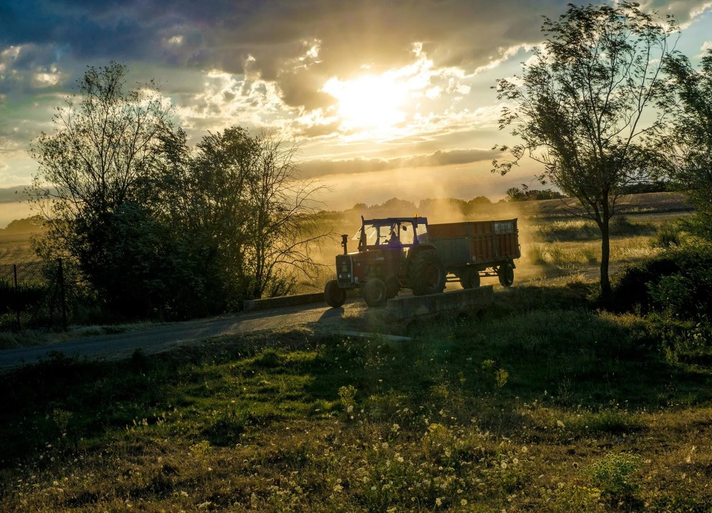 A tractor tows a trailer on a ranch