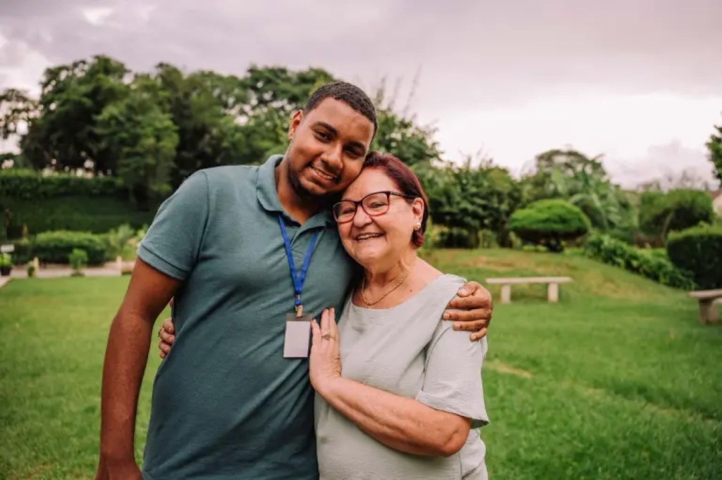 Two smiling people share a hug.