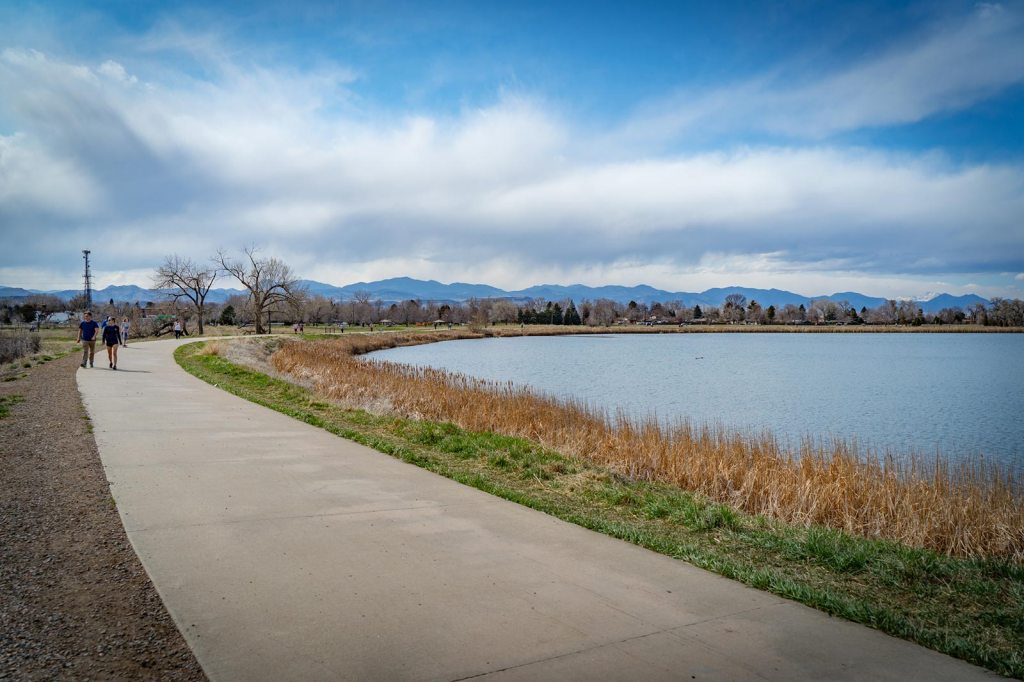 People walk along a lakeside trail in Jefferson County Colorado