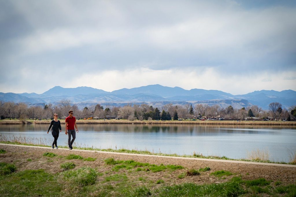 Two people walk down a lakeside trail in Jefferson County