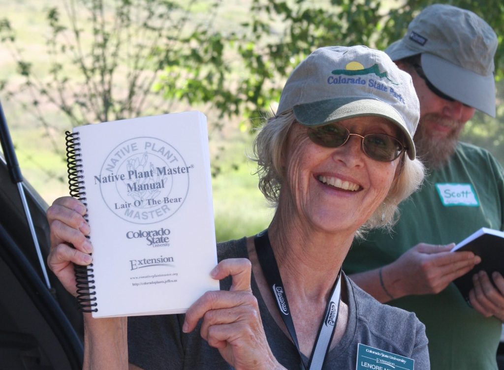 Lenore holding Native Plant Master manual.