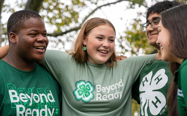 4-H youth members smile and talk outside