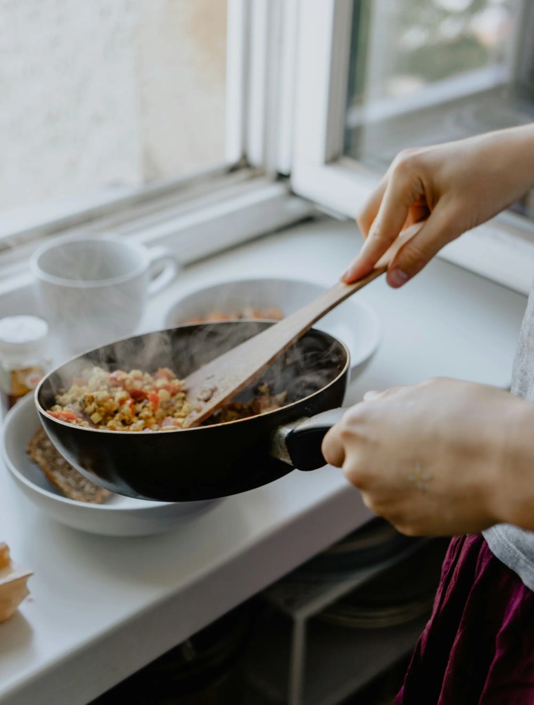 Closeup of a person cooking food on a stove