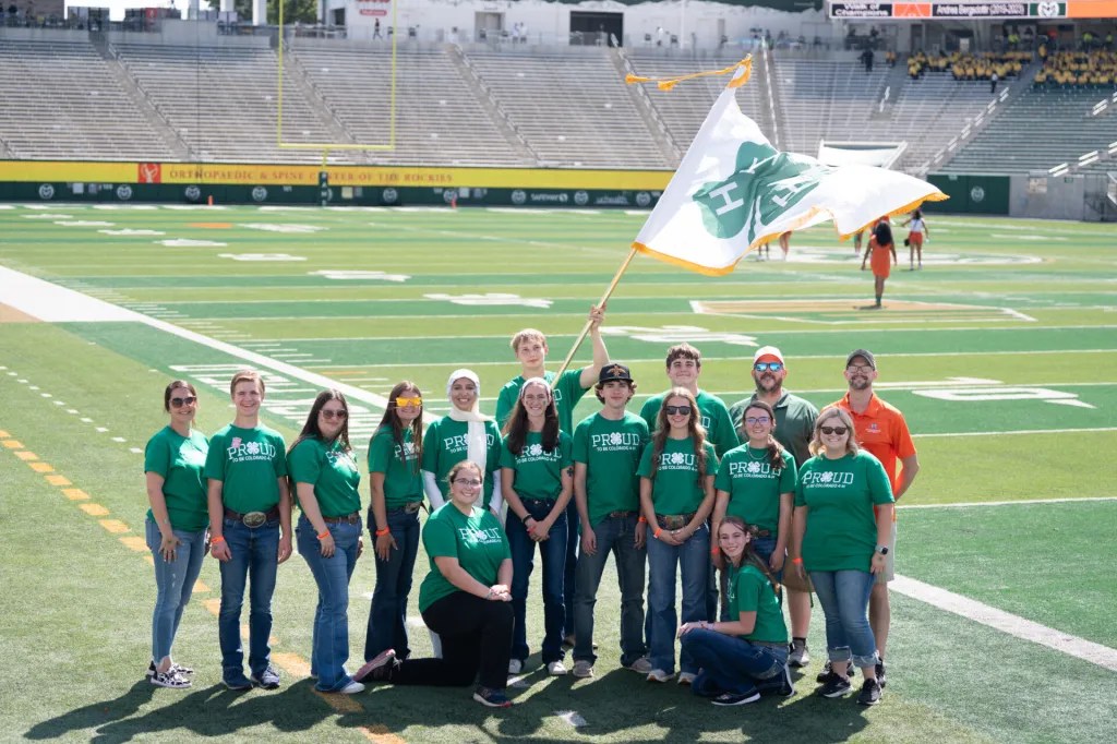 4-H youth stand on the CSU Rams football field on campus.