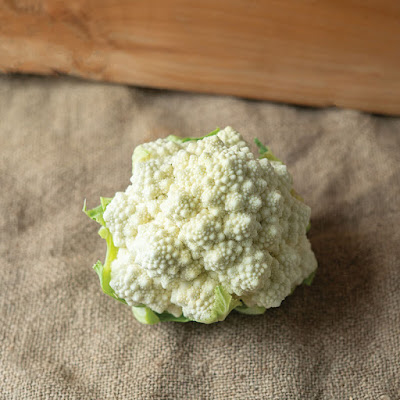 One head of 'Whitaker' romanesco cauliflower on a burlap cloth.