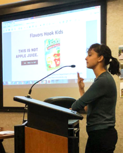 Lilly Reynolds speaking at a podium.