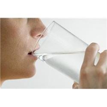 Close up image of a person drinking water out of a glass.