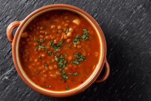 A bowl of cooked beans on a black background
