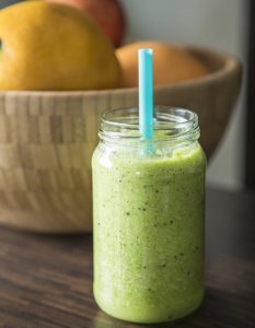 Green smoothly on countertop with a blue straw.