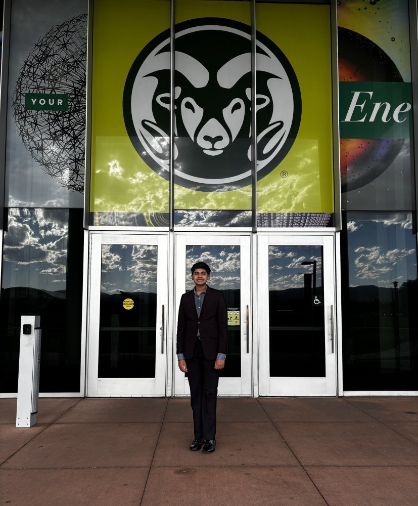 Anirudh Rao standing outside of a CSU building with a large CSU Ram logo behind him.