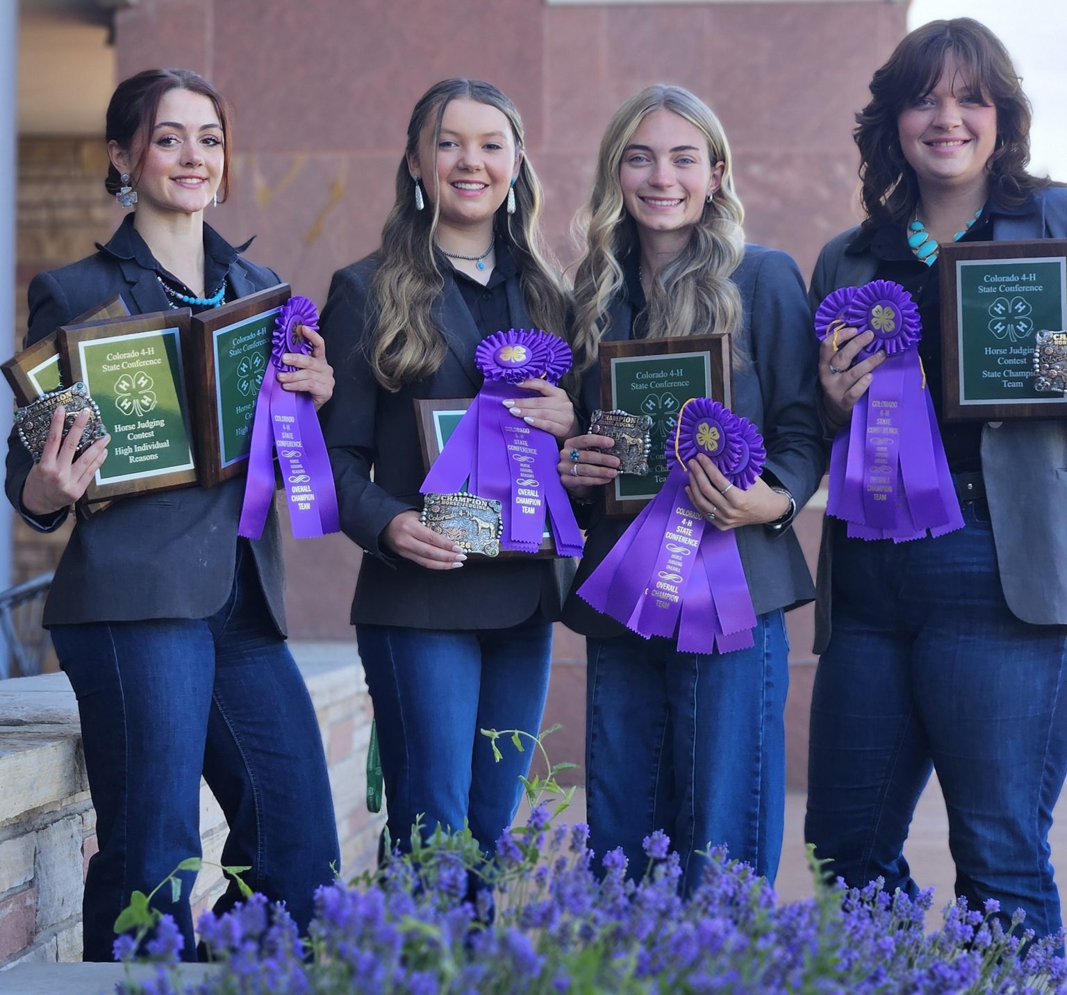 A group of 4-H youth pose for a photo with their awards from the 4-H Horse Judging championship